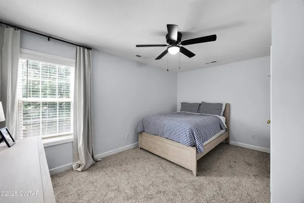 a spacious bedroom with a bed and a large window