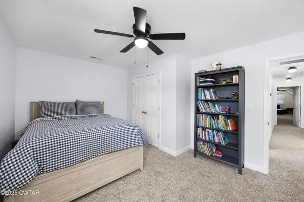 a bedroom with a bed and a book shelf