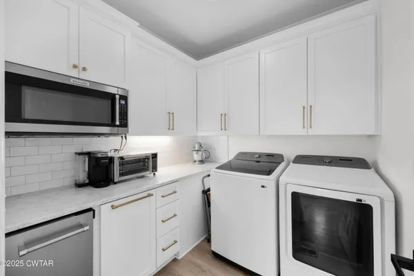 a kitchen with cabinets stainless steel appliances and sink