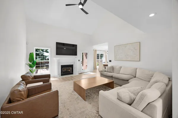 a living room with furniture a flat screen tv and a fireplace
