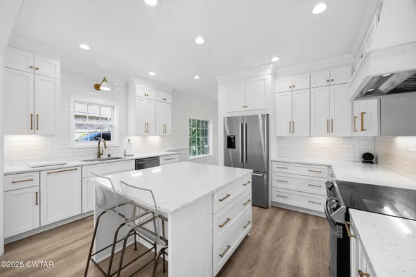 a kitchen with white cabinets and stainless steel appliances