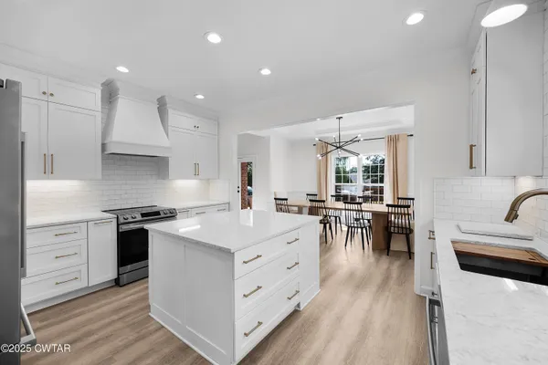 a kitchen with white cabinets and appliances