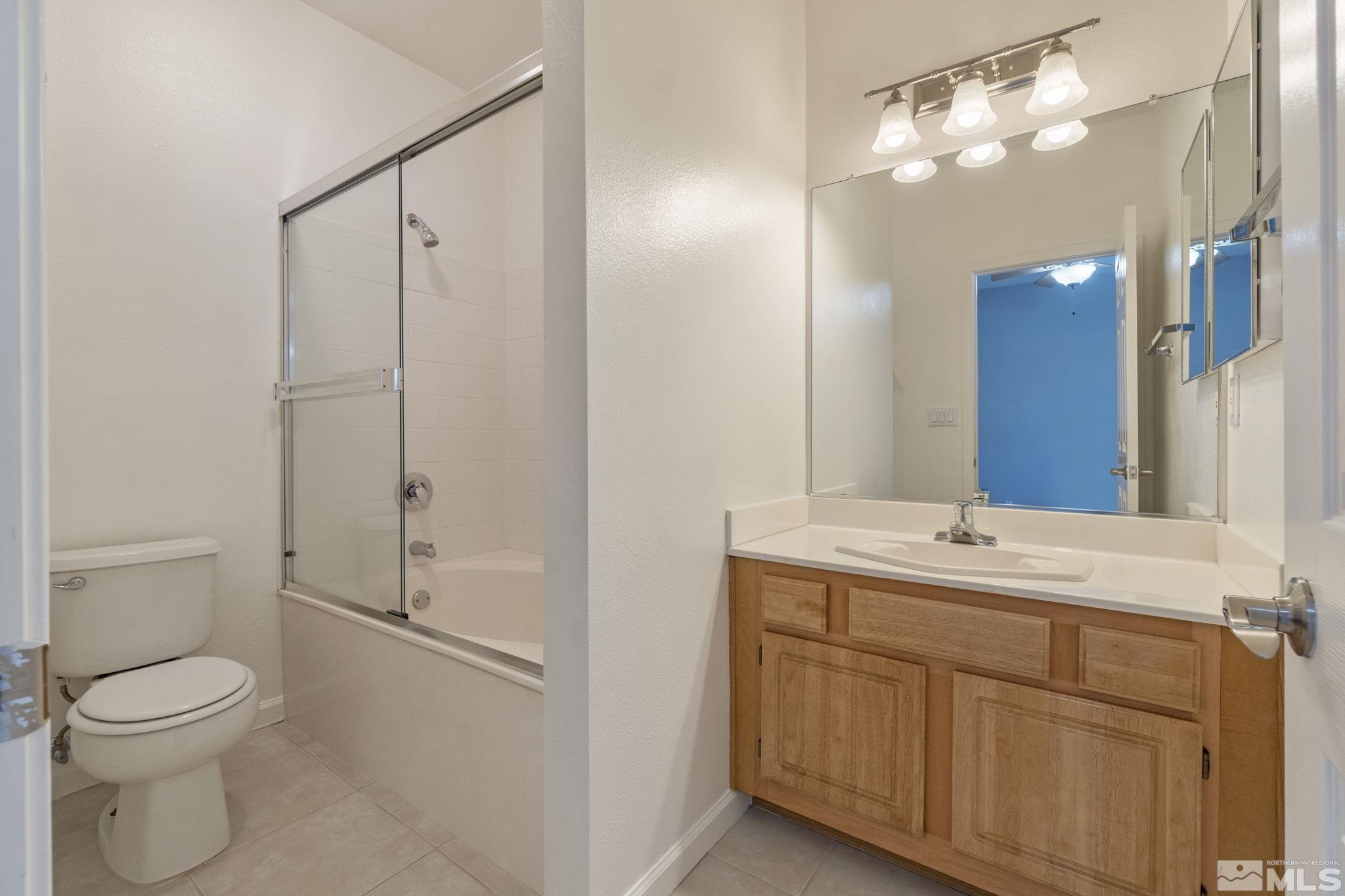 900 South Meadows Parkway, Unit 223 Reno, NV 89521 - Photo 24 of 40 a bathroom with a toilet a sink a mirror and vanity