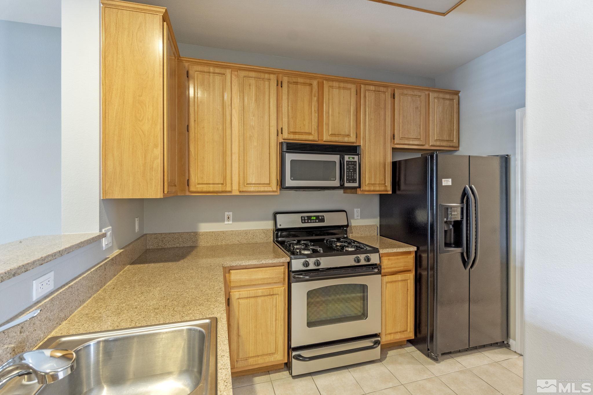 900 South Meadows Parkway, Unit 223 Reno, NV 89521 - Photo 8 of 40 a kitchen with a refrigerator stove and microwave