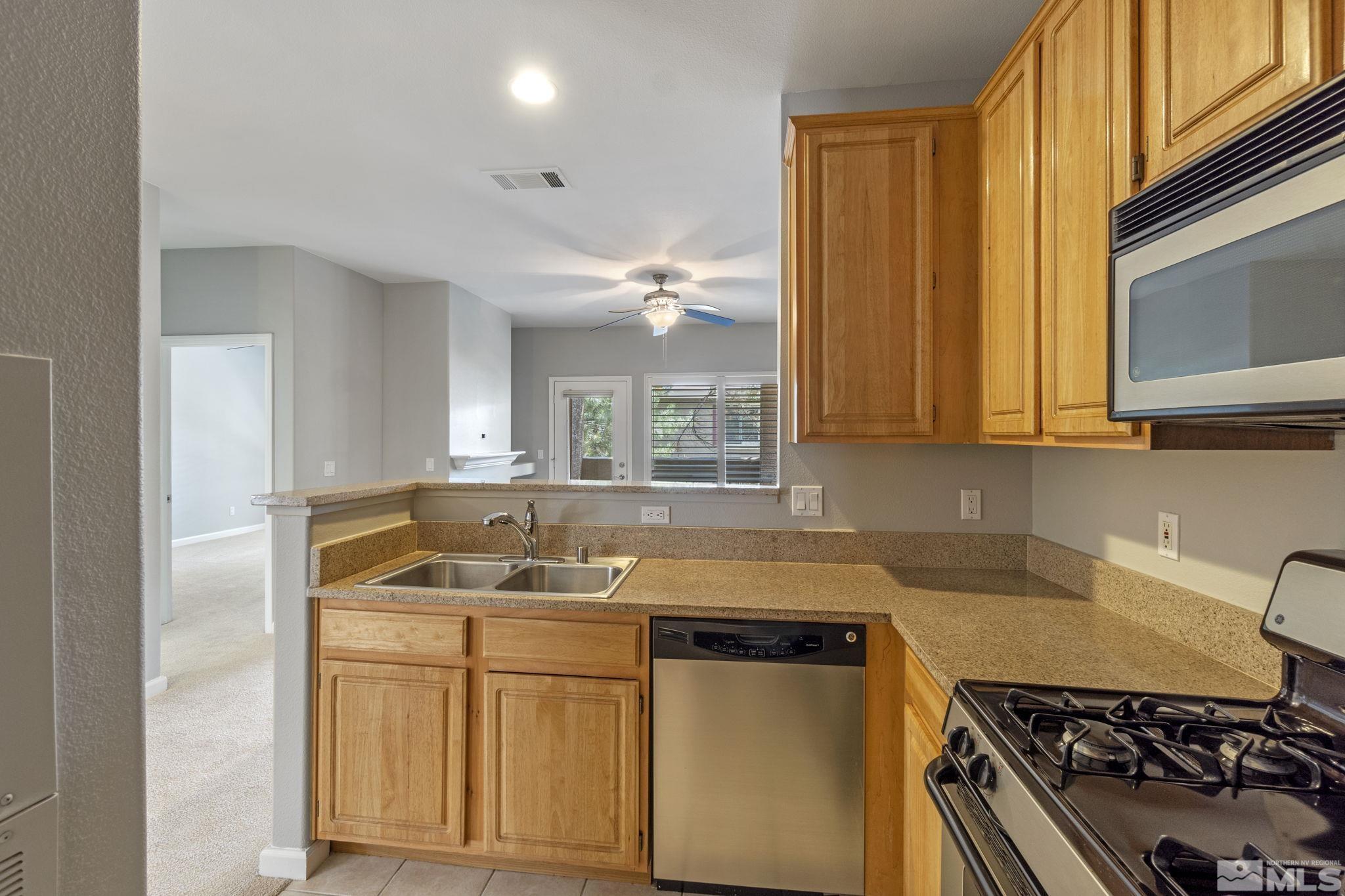 900 South Meadows Parkway, Unit 223 Reno, NV 89521 - Photo 9 of 40 a kitchen with sink a stove and cabinets
