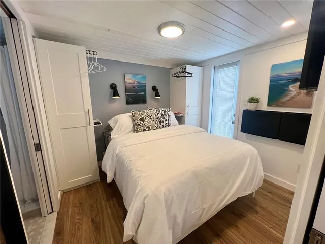 a bedroom with a bed and a flat tv screen on dresser