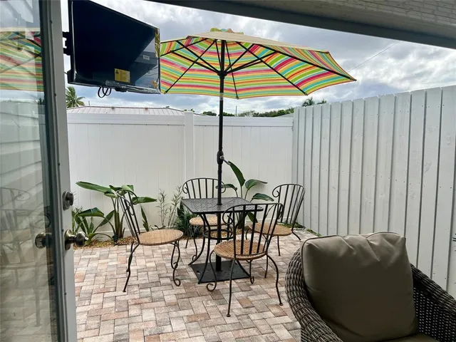 a view of a patio with a table and chairs under an umbrella