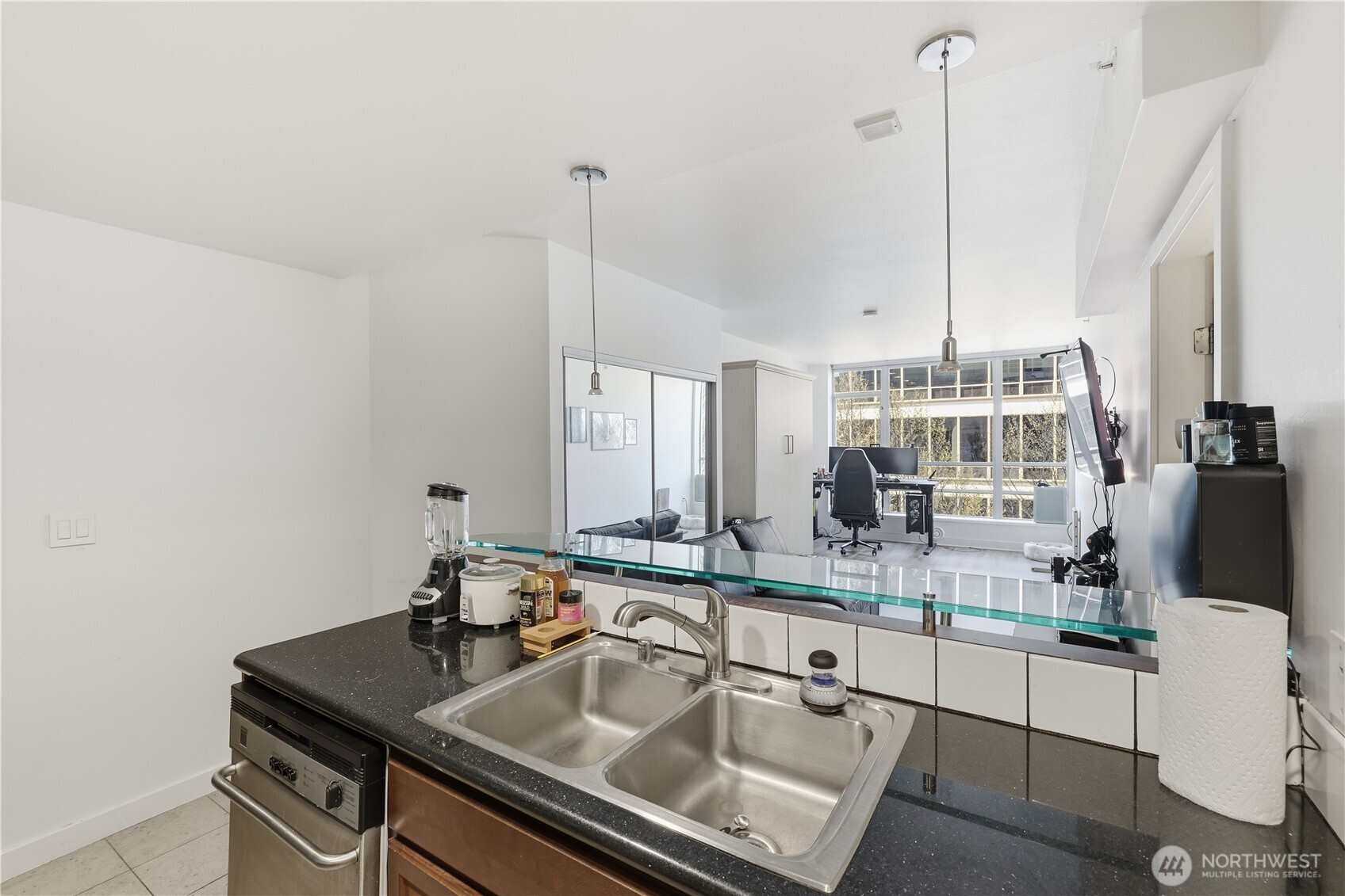 2929 1st Avenue, Unit 201 Seattle, WA 98121 - Photo 13 of 35 a kitchen with stainless steel appliances granite countertop a sink a stove and a wooden floors