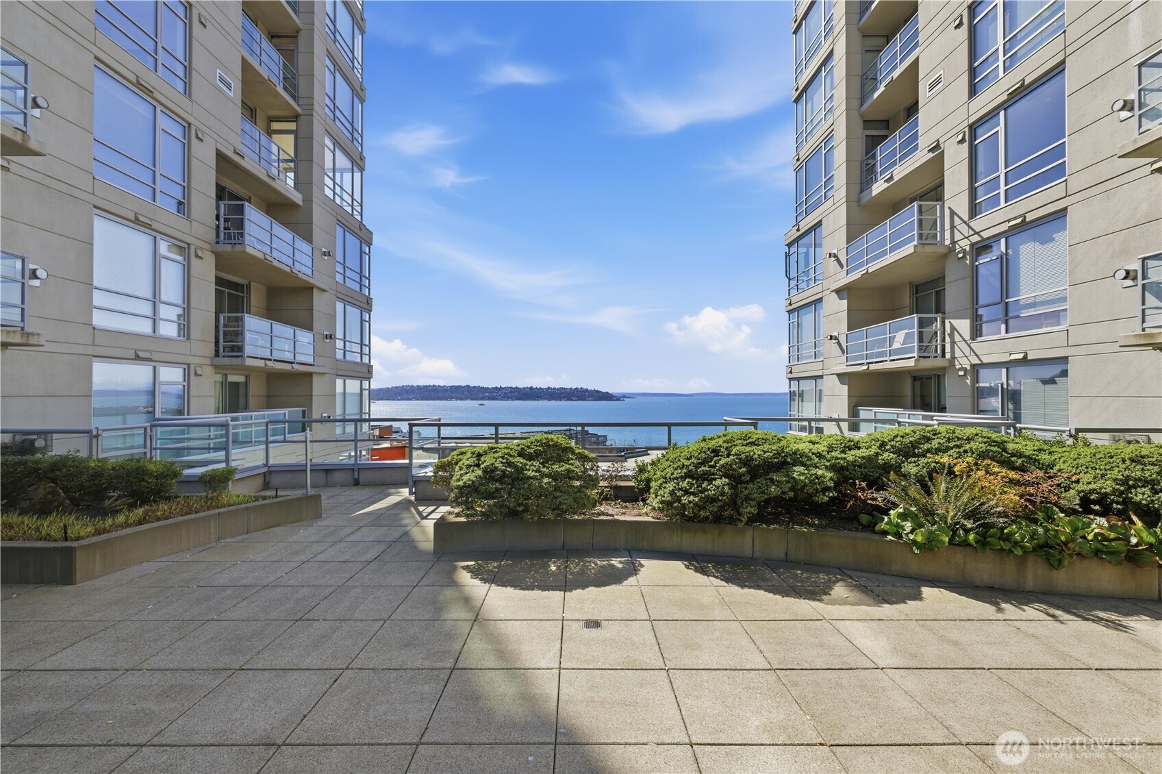 2929 1st Avenue, Unit 201 Seattle, WA 98121 - Photo 20 of 35 a front view of a multi story residential apartment building with yard and bench