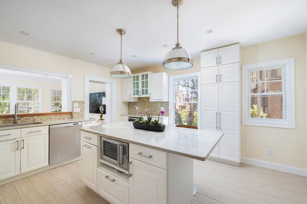 a kitchen with a center island wooden floor and windows
