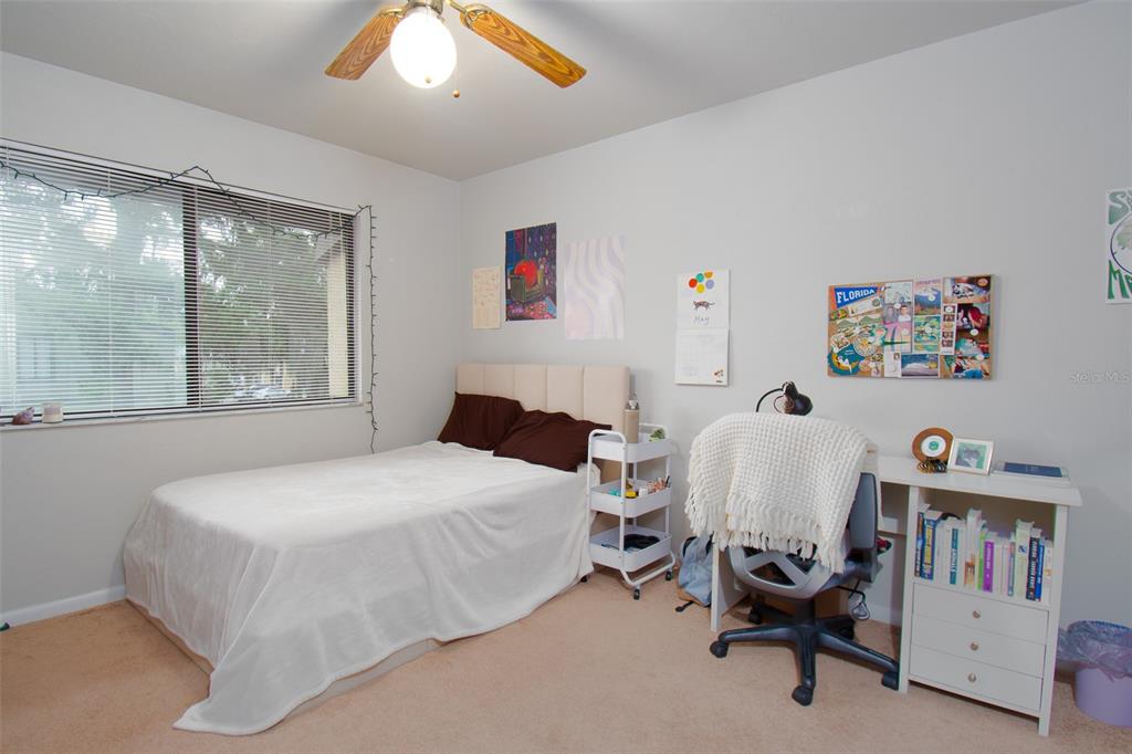 2300 Southwest 43rd Street, Unit K5 Gainesville, FL 32607 - Photo 8 of 18 a bedroom with a bed a large window and book self