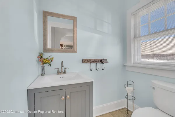 a bathroom with a sink a toilet and mirror