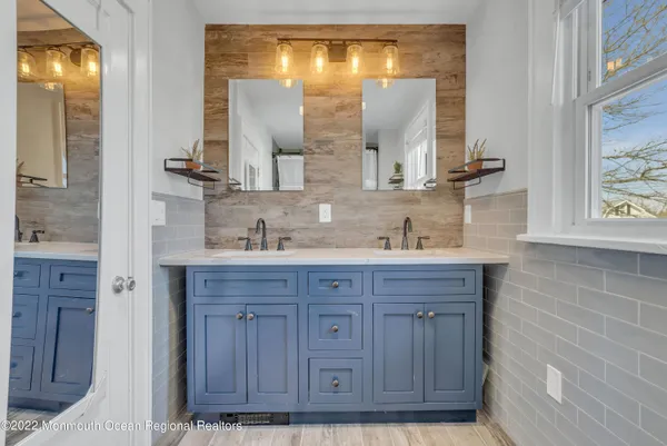 a bathroom with a granite countertop sink a vanity and a large mirror
