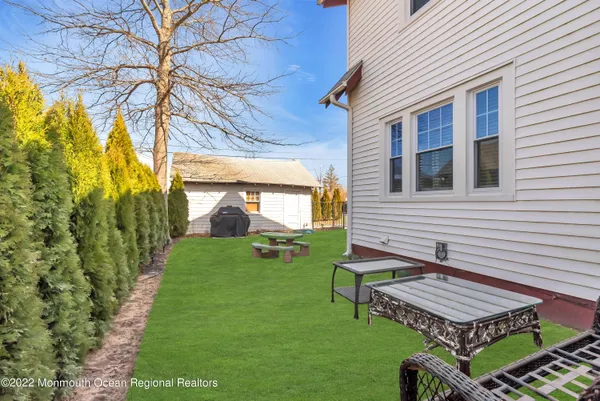 a view of a backyard with table and chairs potted plants and wooden fence