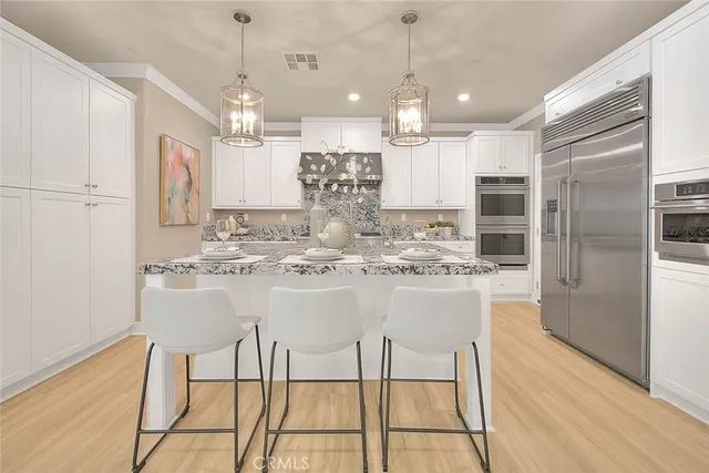 a large kitchen with stainless steel appliances granite countertop a lot of counter space and wooden floor