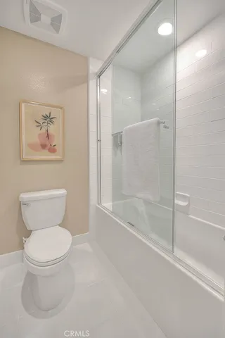 a bathroom with a toilet a sink a mirror and a window