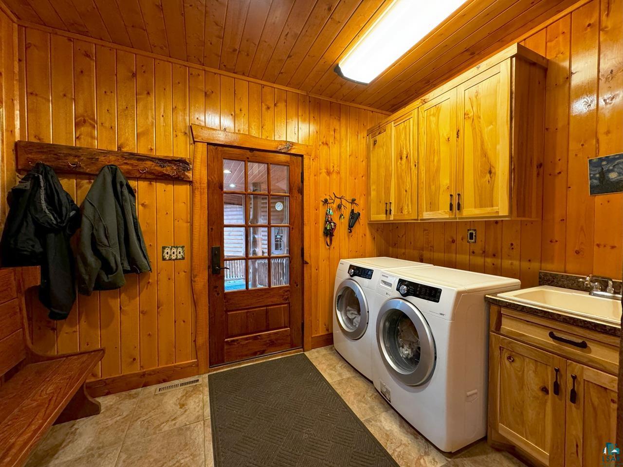 7236 Far North Road Orr, MN 55771 - Photo 20 of 42 Laundry room with cabinet space, wooden ceiling, wood walls, and washer and dryer