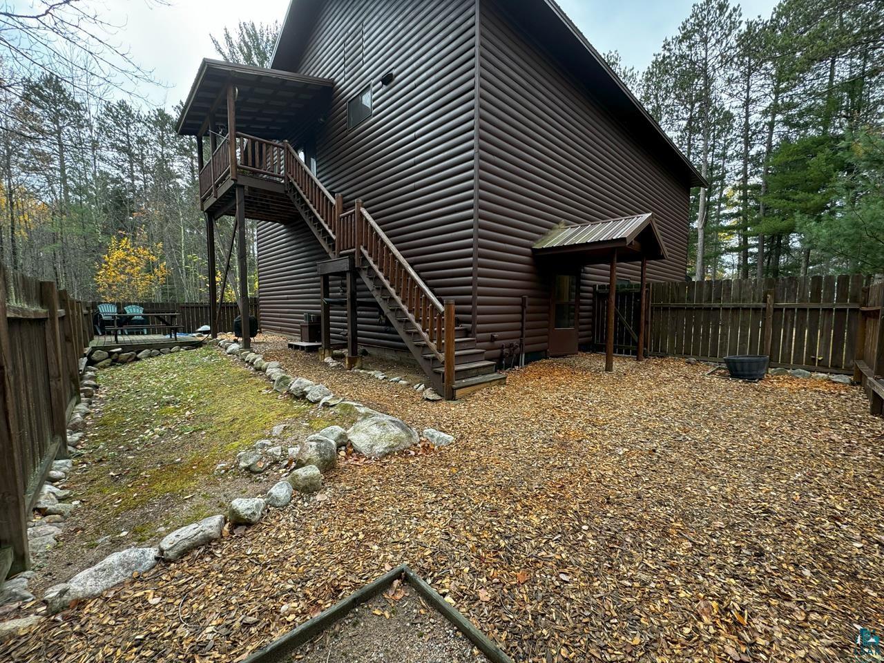 7236 Far North Road Orr, MN 55771 - Photo 34 of 42 View of side of home with log veneer siding, stairs, and a fenced backyard