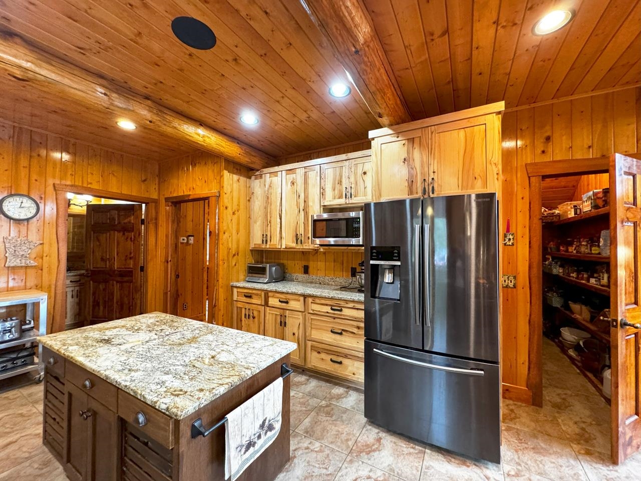 7236 Far North Road Orr, MN 55771 - Photo 7 of 42 Kitchen featuring appliances with stainless steel finishes, wood ceiling, wooden walls, recessed lighting, and light stone countertops