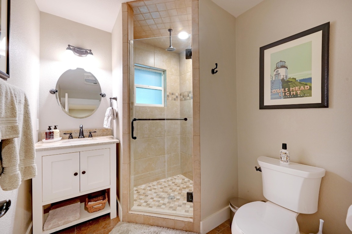 1020 River Road Wimberley, TX 78676 - Photo 25 of 40 a bathroom with a toilet a sink and a mirror
