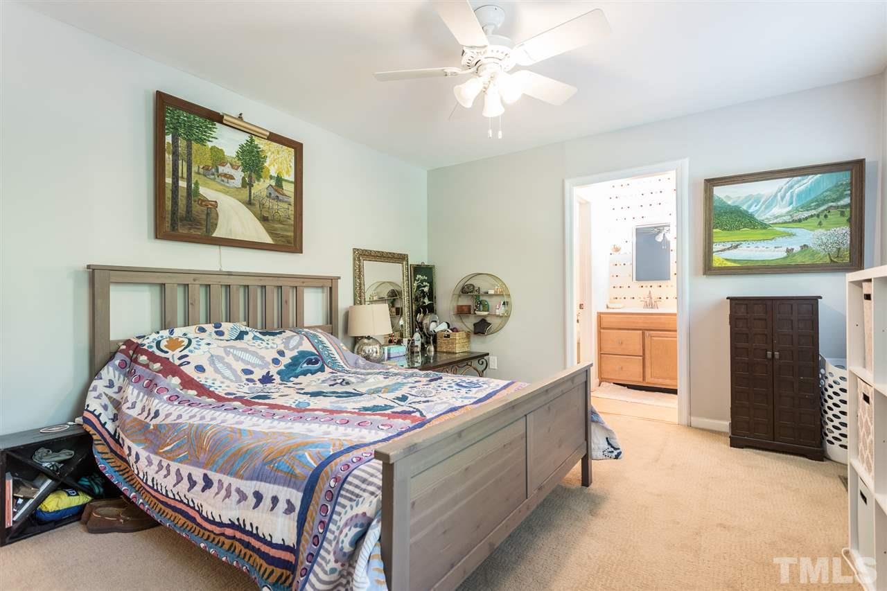 7535 Mine Valley Road Raleigh, NC 27615 - Photo 13 of 26 a bedroom with a bed and a chandelier