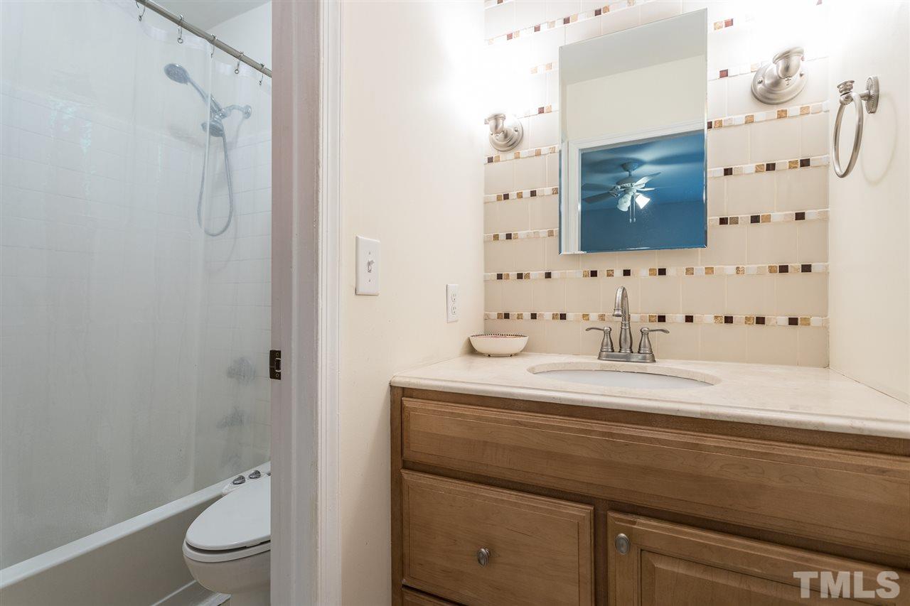 7535 Mine Valley Road Raleigh, NC 27615 - Photo 14 of 26 a bathroom with a granite countertop sink a toilet and shower