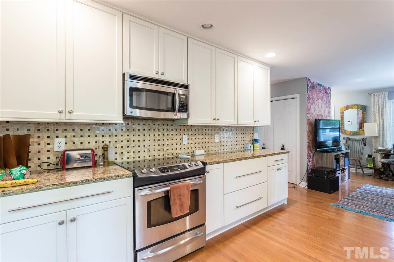 7535 Mine Valley Road Raleigh, NC 27615 - Photo 10 of 26 a kitchen with granite countertop white cabinets and stainless steel appliances