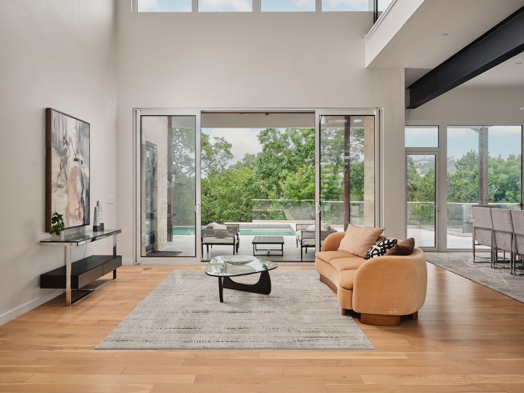 2476 Waymaker Way Austin, TX 78746 - Photo 5 of 31 Natural light floods this living area, offering grand views of the surrounding green landscape.