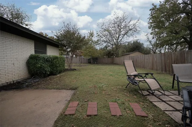a backyard of a house with table and chairs