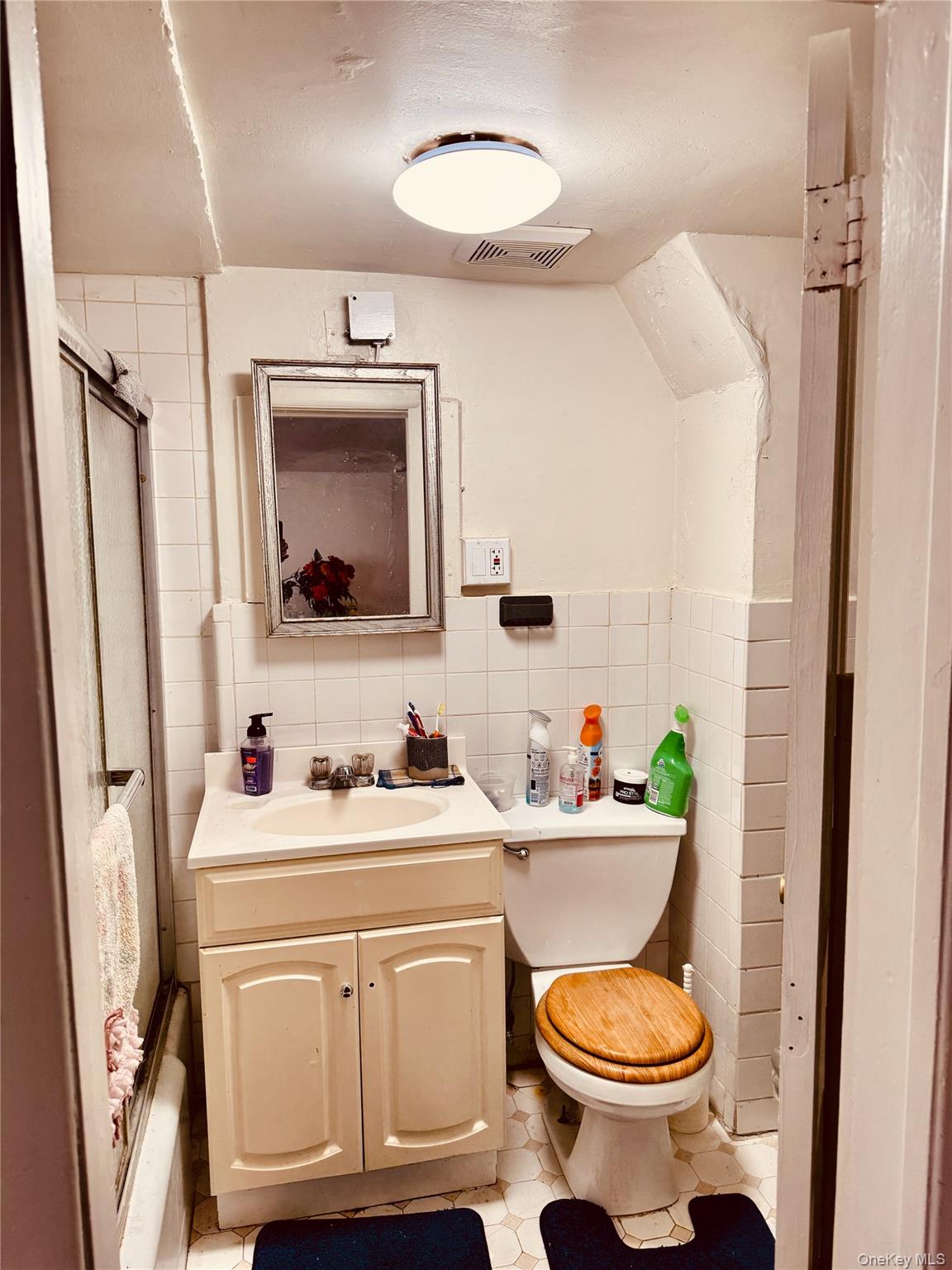 138 West Kingsbridge Road Mount Vernon, NY 10550 - Photo 4 of 6 a bathroom with a toilet sink and mirror