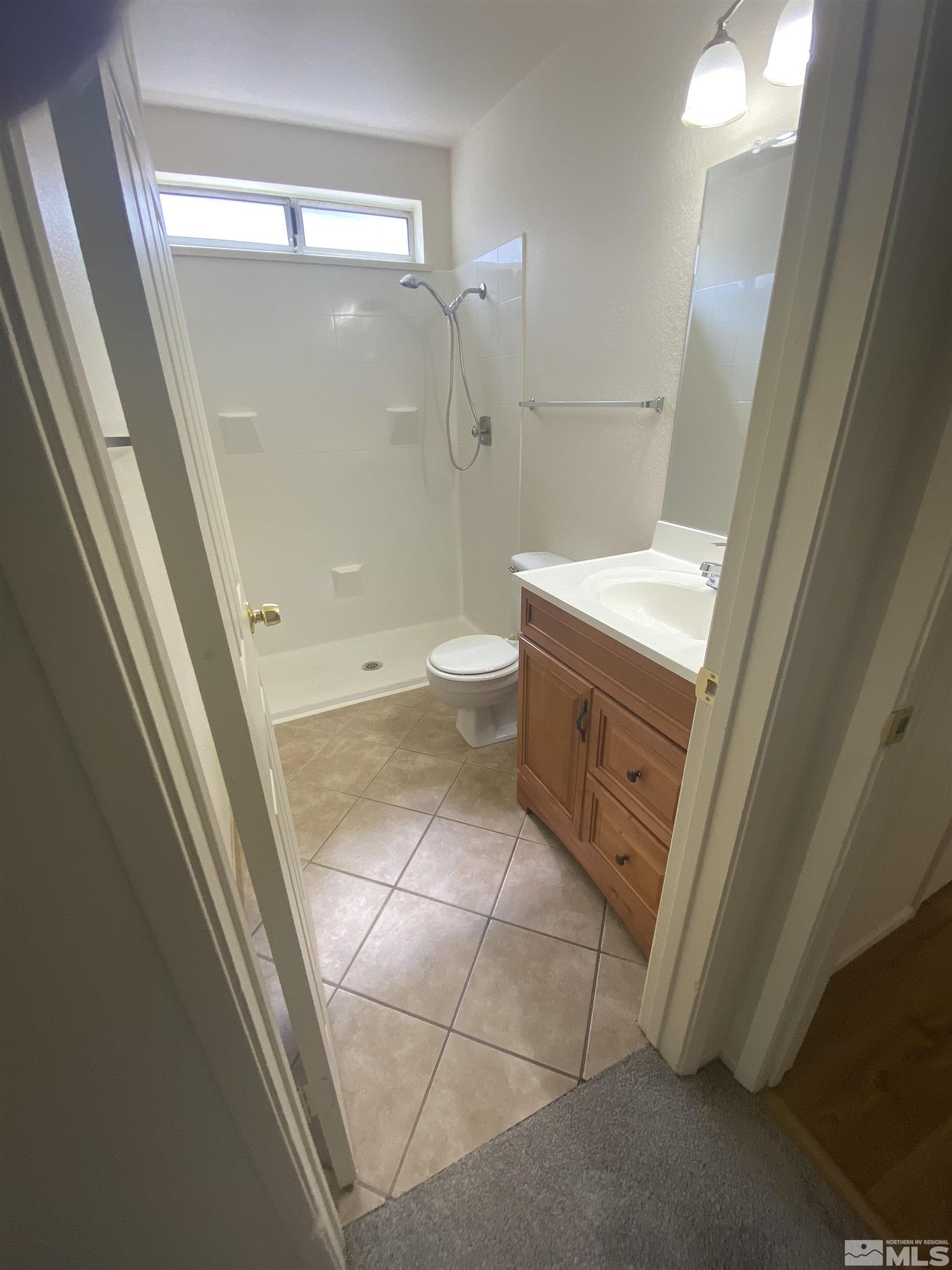 15004 Cuprite Street Reno, NV 89506 - Photo 8 of 22 a bathroom with a granite countertop sink toilet and shower