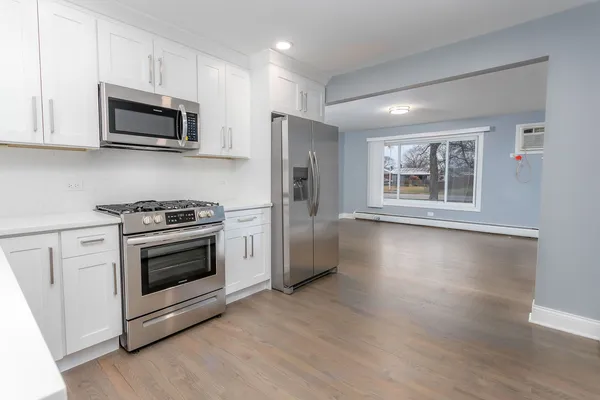 a kitchen with granite countertop a refrigerator stove and microwave