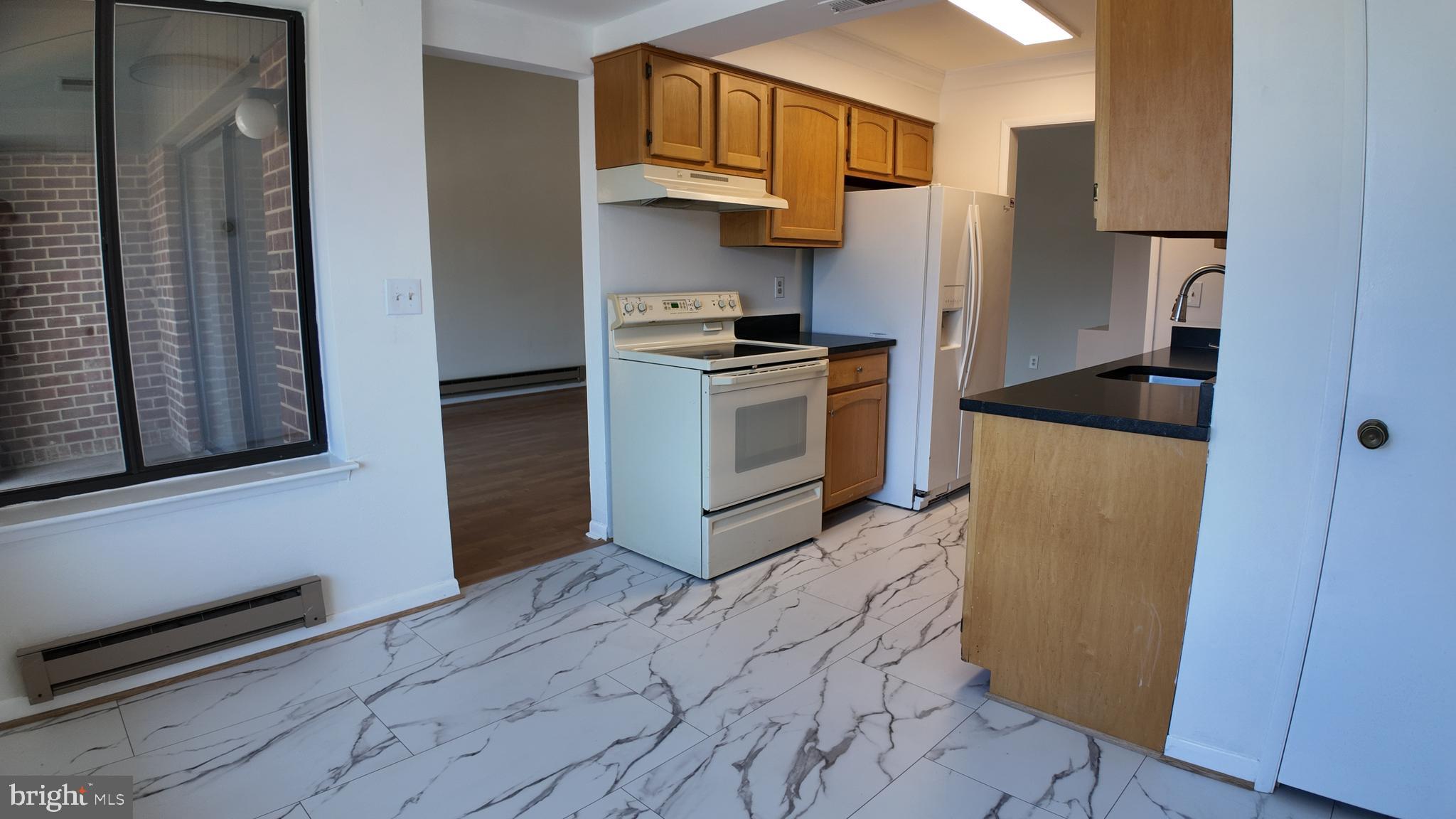 15311 Beaverbrook Court, Unit 903B Silver Spring, MD 20906 - Photo 15 of 36 a kitchen with a refrigerator and a stove