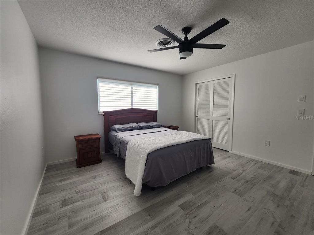 900 Crestwood Road Englewood, FL 34223 - Photo 14 of 38 a spacious bedroom with a bed and a ceiling fan