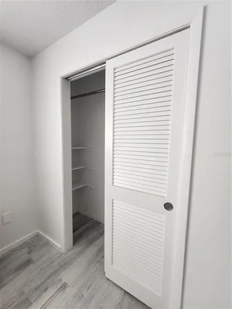 an empty room with wooden floor and closet