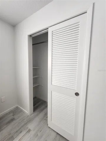 an empty room with wooden floor and closet