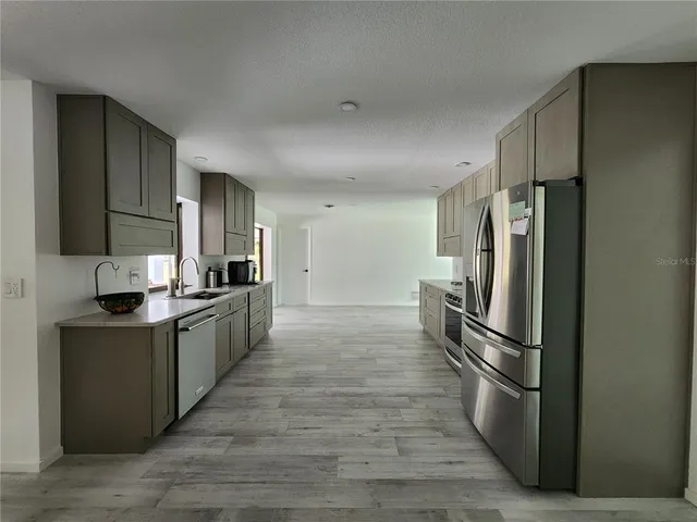 a kitchen with stainless steel appliances a refrigerator and a sink