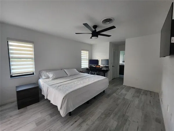 a spacious bedroom with a bed and a chandelier