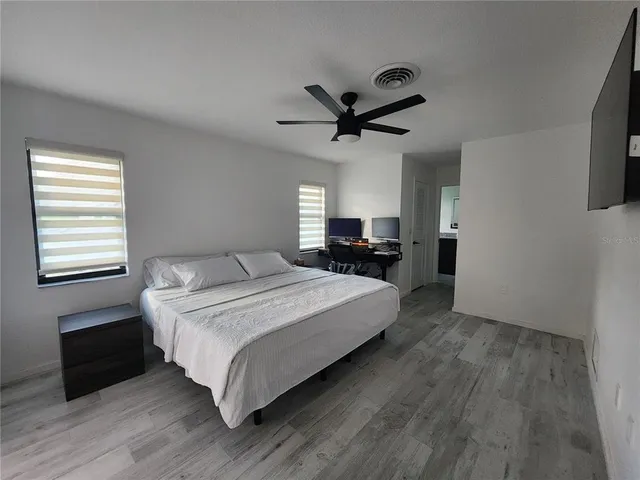 a spacious bedroom with a bed and a chandelier