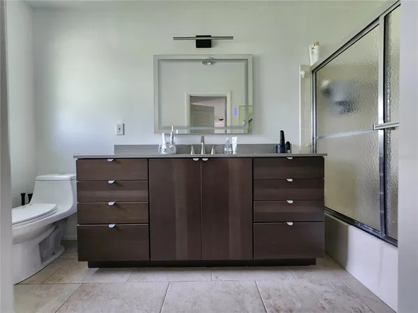 a bathroom with a granite countertop sink a toilet and a mirror