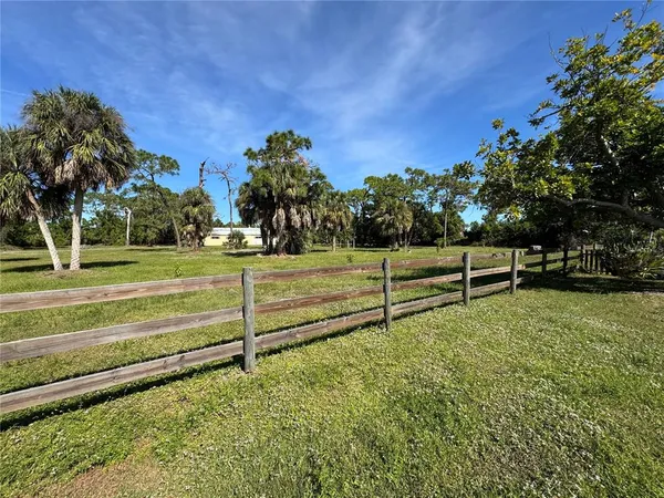 a view of a yard with wooden fence