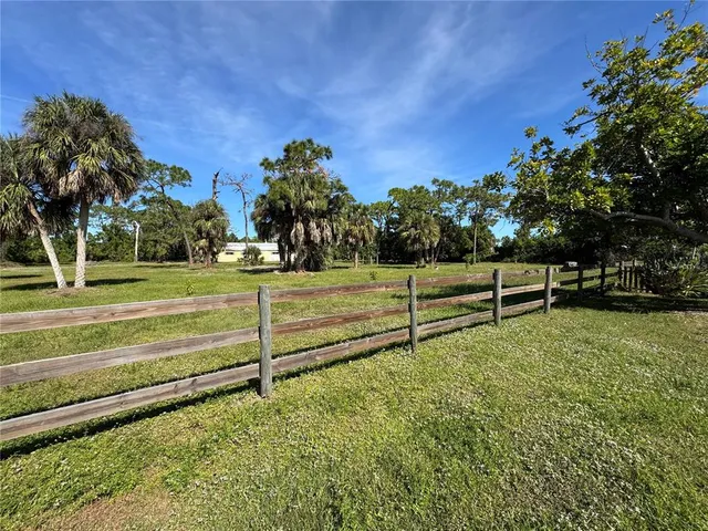 a view of a yard with wooden fence