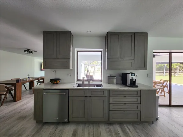 a kitchen with granite countertop a sink cabinets and wooden floor