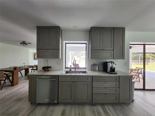 a kitchen with granite countertop a sink cabinets and wooden floor