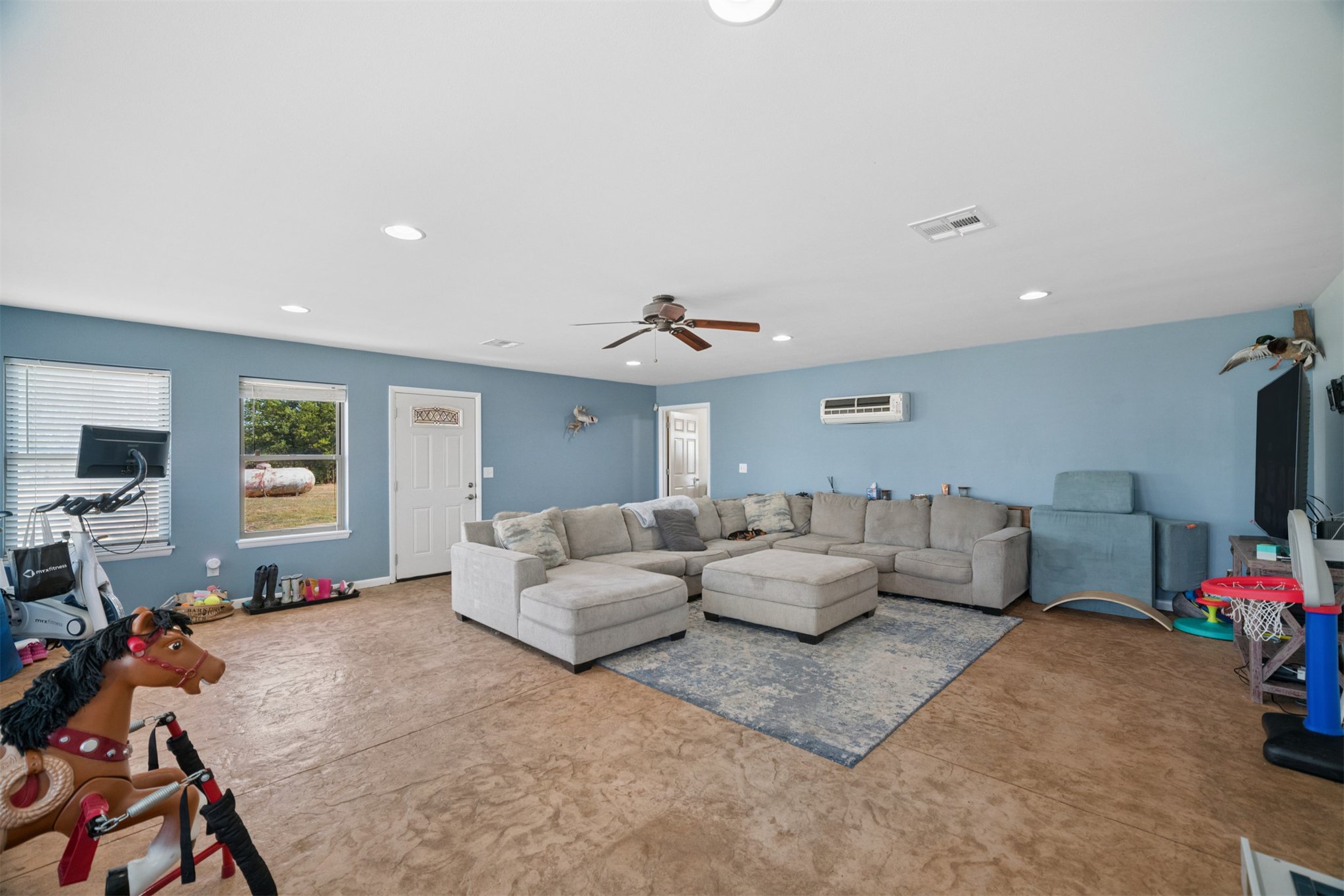 49301 South 360 Road Pawnee, OK 74058 - Photo 27 of 44 Spacious living area featuring stamped concrete flooring, soft blue wall tones, recessed lighting, a ceiling fan, and multiple windows