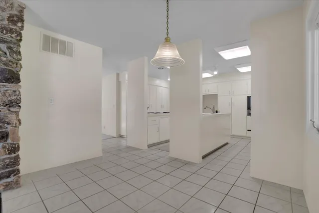 a view of a refrigerator in kitchen and white cabinets