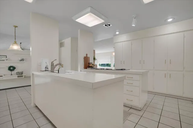 a kitchen with white cabinets and sink