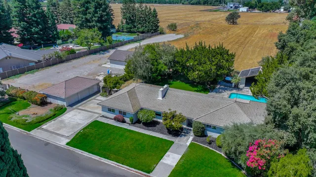 an aerial view of a house with garden space and lake view