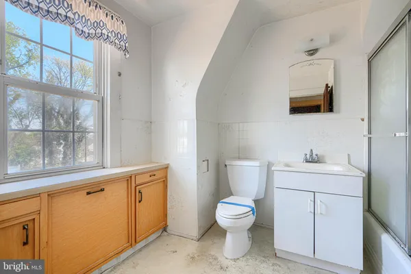 a bathroom with a toilet a sink and a window