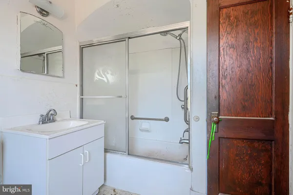 a bathroom with a shower sink and mirror